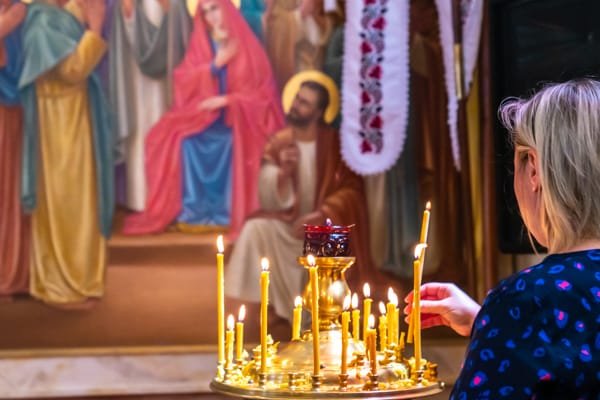 Молитва та свічки перед святими іконами у соборі Володимира
